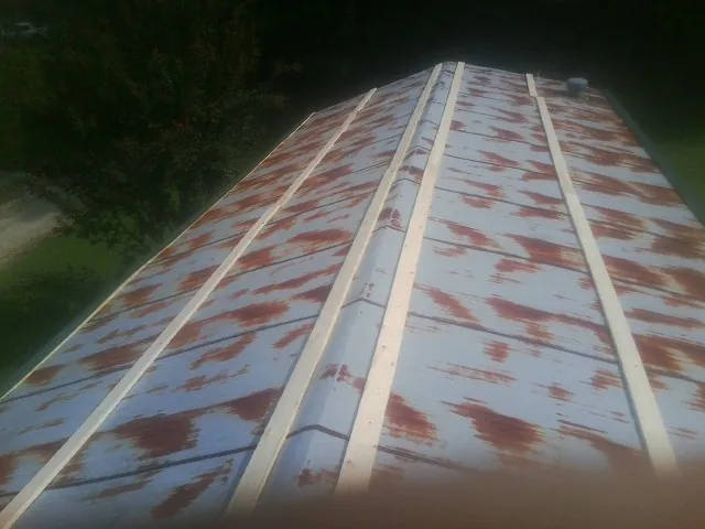 Rusted metal roof panels with new wood purlins before replacement — Storm Damage Roof Repair in Yancey by Roofing Brothers
