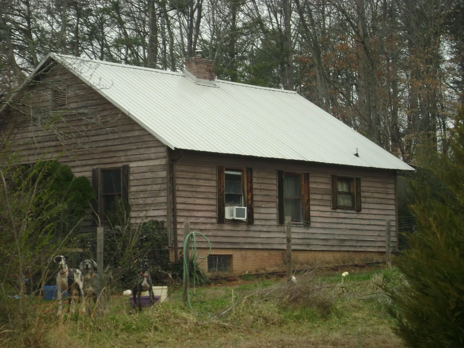 White metal roof on an old wood sided farmhouse, from a Metal Roof Installation job in Yancey